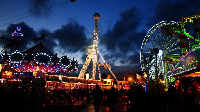holiday theme park in london at night with many lit-up multicoloured rides