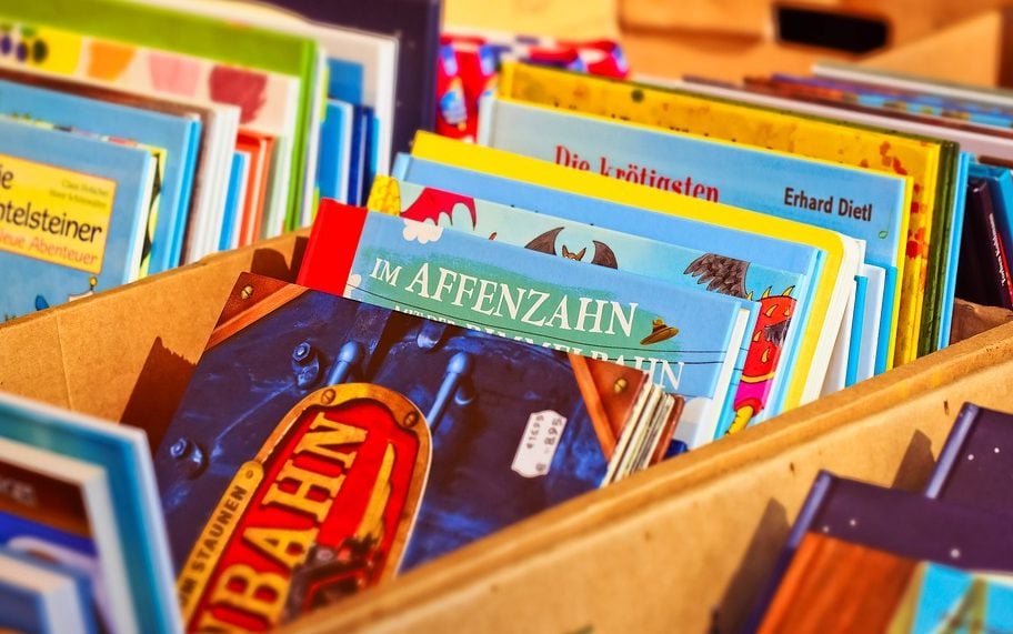 a stack of children's books in a wooden box