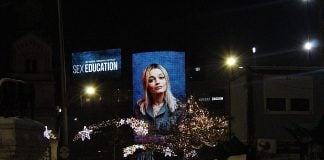 A board displaying the face of an actress from the television show Sex Education.
