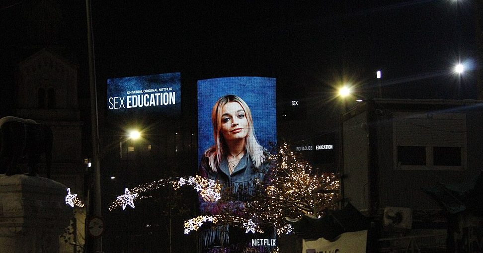 A board displaying the face of an actress from the television show Sex Education.