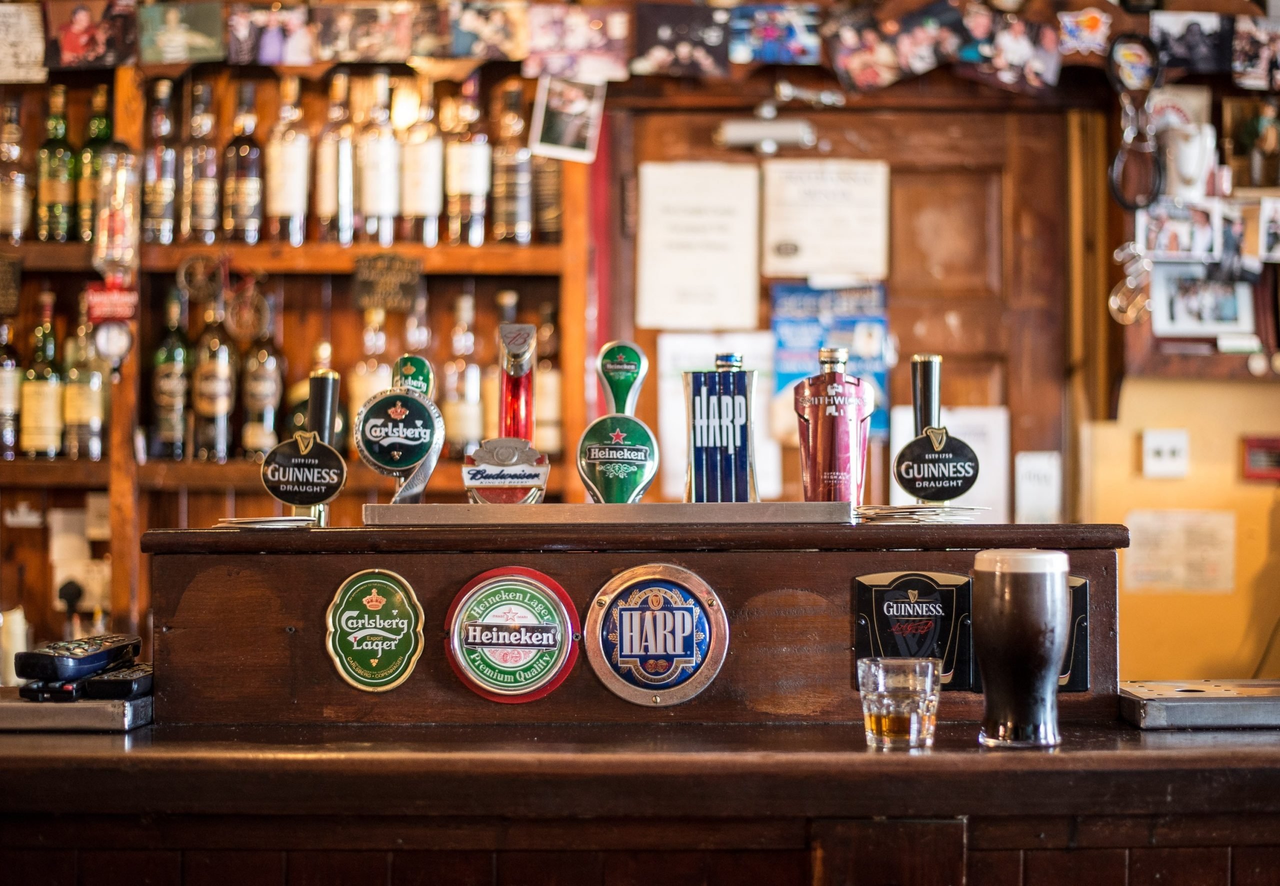 A traditional pub's beer taps behind its wooden counter.
