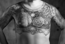 A black and white image of a man's chest featuring a large tattoo