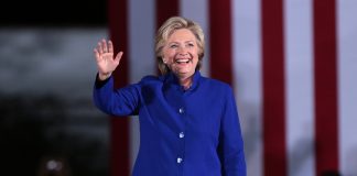 Hillary Clinton in a blue suit waving