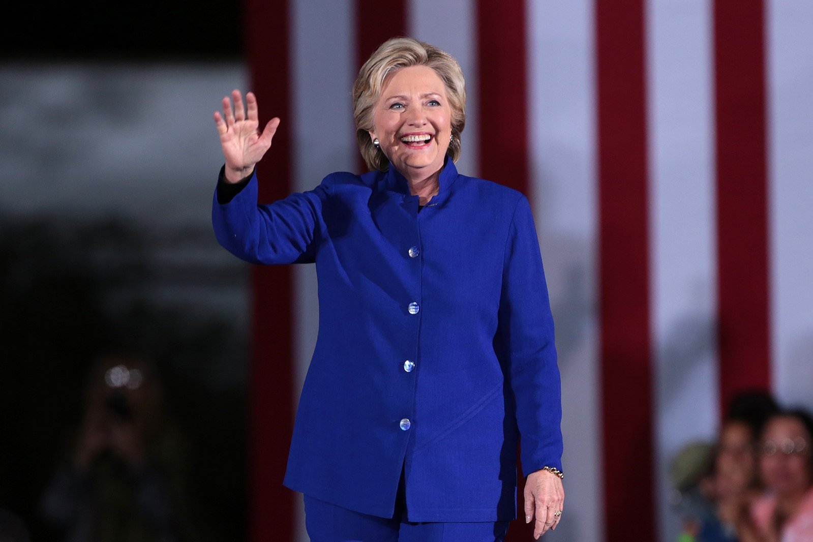 Hillary Clinton in a blue suit waving
