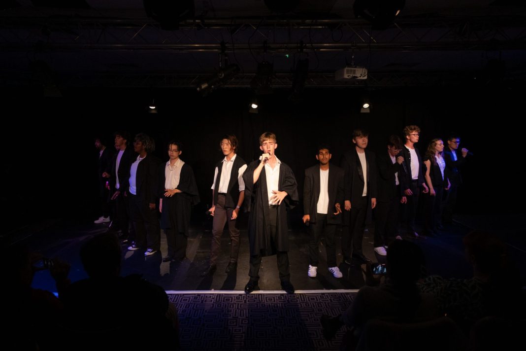 Row of Oxford Commas performers singing