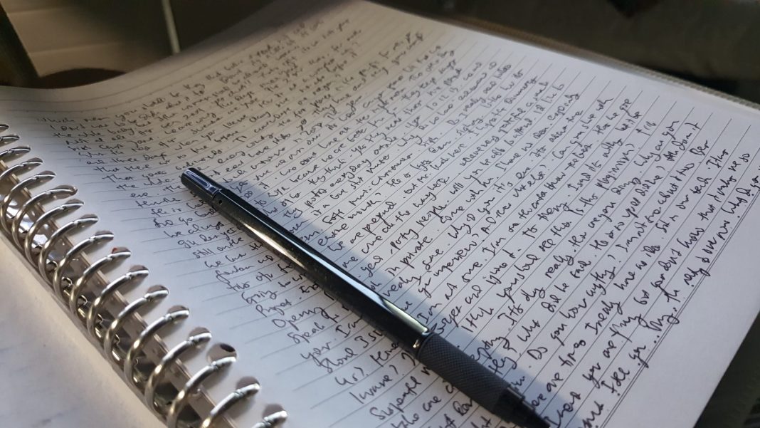 Notebook with writing on it and a pen