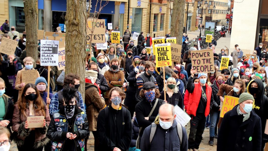 Group of protestors wearing masks and holding signs.